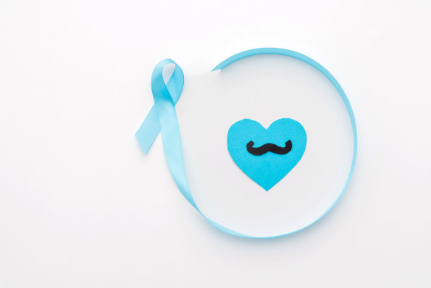 剪纸胡子在蓝色的心脏内蓝色大丝带，前列腺癌意识白底图片下载