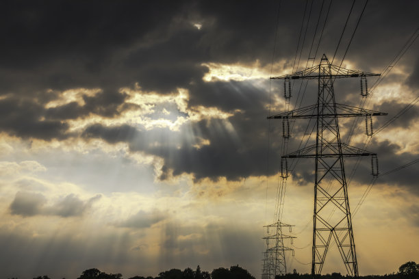 日落时暴风雨中的高压电线图片下载