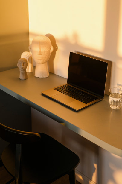 职场秩序在桌子上的垂直镜头:现代上网本，桌面上的玻璃和陶瓷装饰图片下载