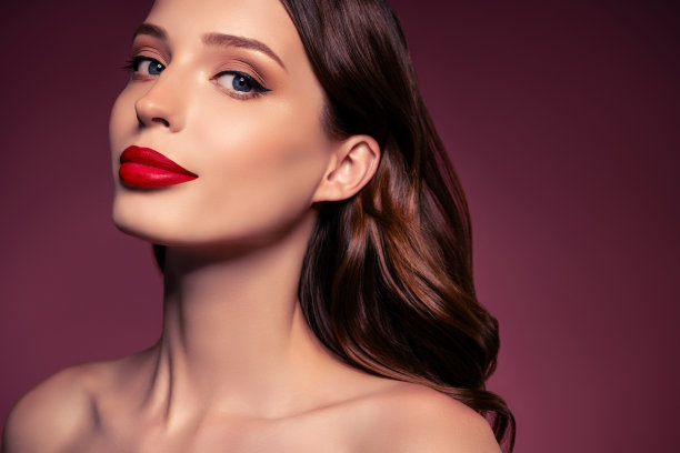 照片的黑发女士与化妆红口红看在相机孤立的棕色背景图片下载