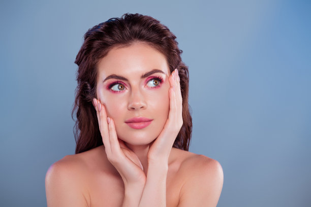 照片中的黑发女子摸着脸，皮肤看起来空白，空间孤立，背景颜色柔和图片下载