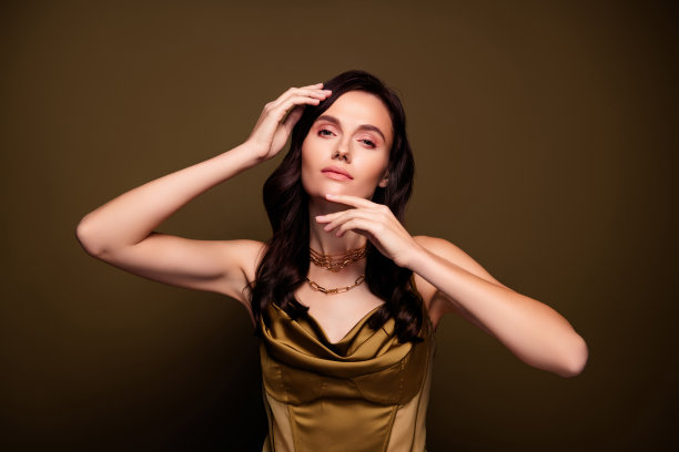 照片的惊人魅力花式女士穿着丝绸卡其色连衣裙摆出棕色渐变色的背景图片下载