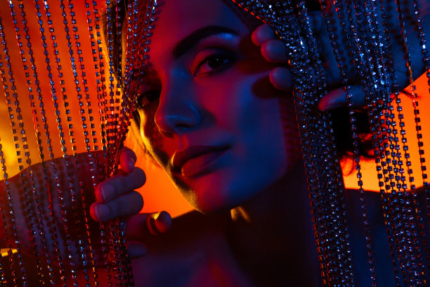 照片上漂亮酷的女士戴着什么都不开的宝石窗帘，背景是孤立的橙色滤色图片下载