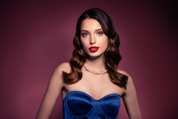 照片中的女孩在镜头前穿着蓝色时尚的礼服配饰珠宝孤立的棕色背景图片下载