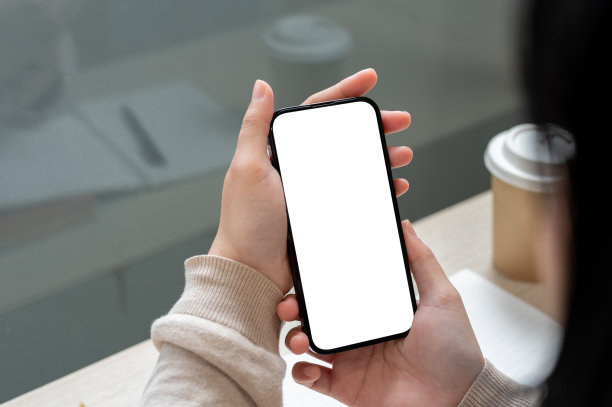 一名亚洲女性坐在室内使用智能手机的特写照片。智能手机模型图片下载