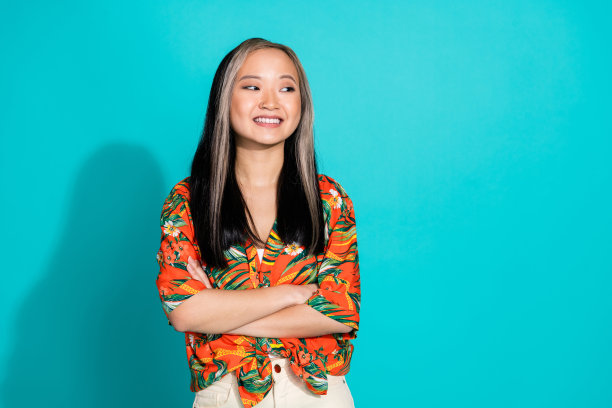 照片中闪亮迷人的女士穿着印花衬衫，双臂折叠，看起来空白，孤立的蓝色背景图片下载
