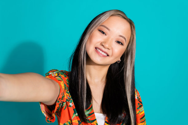 可爱可爱的女孩博主的照片穿着时尚的印花衣服，使vlog孤立的青色背景图片下载