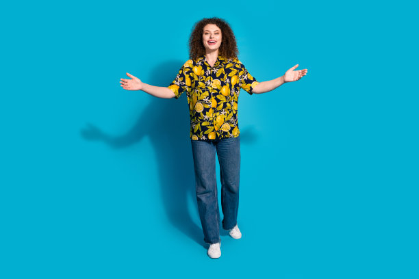 全身照片迷人的积极的女人穿印花衬衫张开双臂拥抱你空旷的空间孤立的蓝色背景图片下载