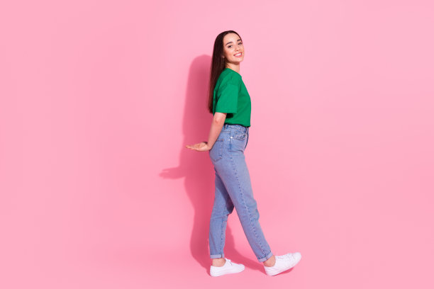 漂亮的刺女士穿着绿色t恤拉胳膊腿空的空间孤立的粉红色背景的全长照片图片下载