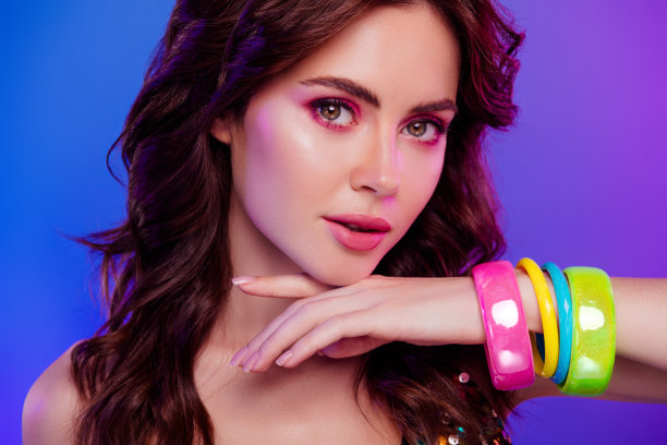 照片肖像漂亮的年轻女孩触摸下巴柔软的皮肤化妆品孤立的复古霓虹灯背景图片下载