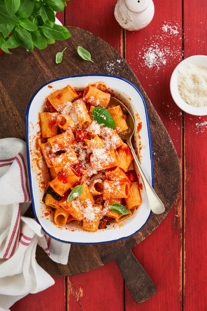 意大利通心粉配帕尔马干酪，番茄帕萨塔酱和罗勒在复古的盘子里，旧的木制红色质朴的桌子背景。传统意大利面食食谱。封面或文章前视图。图片下载