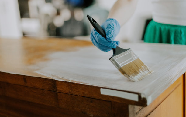 一个年轻的女孩在粉刷一个旧衣柜。图片下载