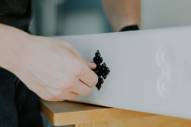 一个年轻人正在修理一个抽屉上的复古把手。图片下载