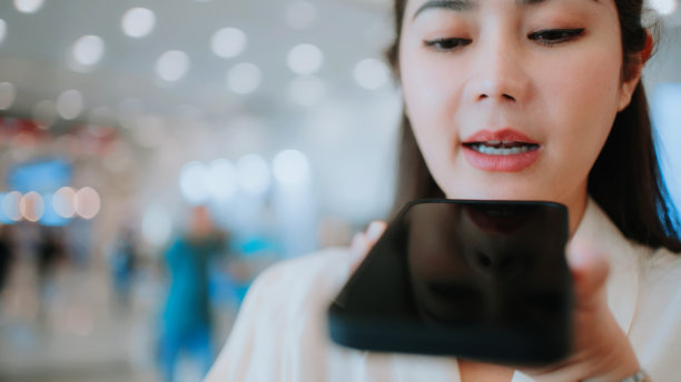 女性在智能手机上使用Ai语音助手。图片下载