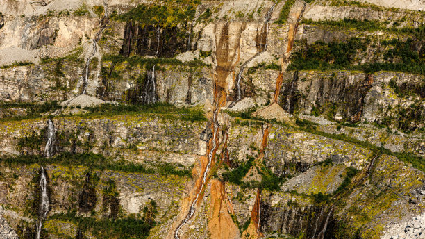 这张照片显示了一个岩石悬崖，从上面看，瀑布倾泻而下图片下载