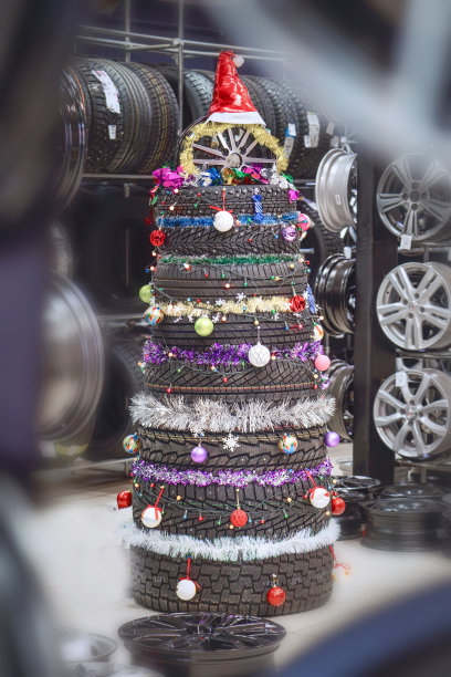 在一家汽车商店，一棵由轮胎制成的创意圣诞树是一种喜庆而环保的装饰图片下载
