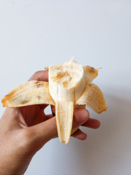 手拿香蕉。生有机健康食品水果。杂货店和超市的烹饪和吃孤立的白色背景图片下载