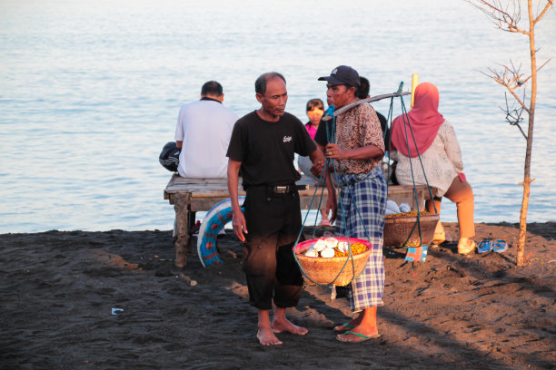 一位老人早上在马塔兰的Loang Baloq海滩上卖东西图片下载