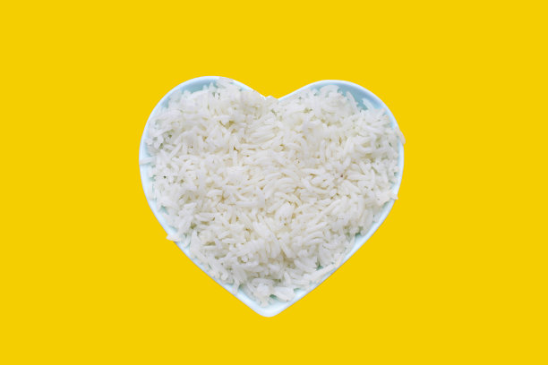 黄色背景的碗里煮熟的米饭。图片下载