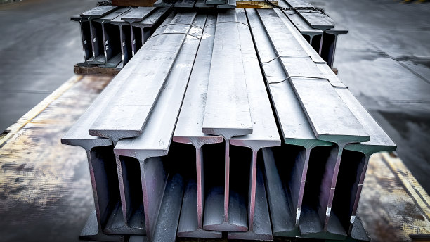 金属制品仓库的金属型材梁。工字钢结构，仓库内法兰梁，钢梁放置在钢架上，钢结构，施工现场图片下载