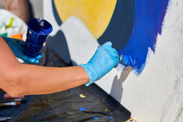 女画家用手热情地用画笔为街头展览画特写图片下载