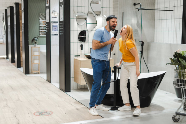 一个男人和一个女人一起站在水暖铺里，唱着歌挑选新浴缸图片下载