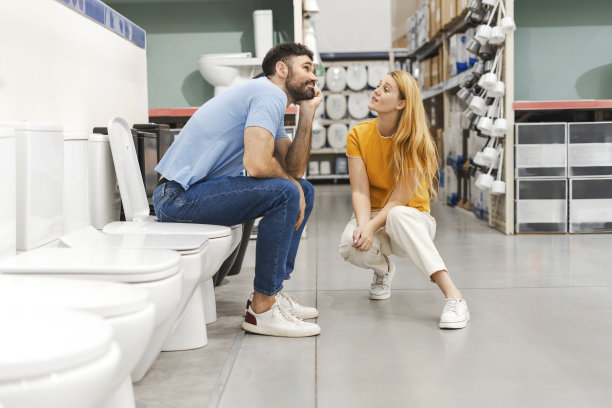 年轻夫妇在五金店挑选新马桶图片下载