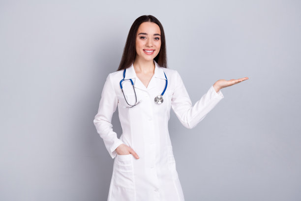 照片中的专业医务人员女士抱着空白的空间，白色外套孤立在灰色背景上图片下载