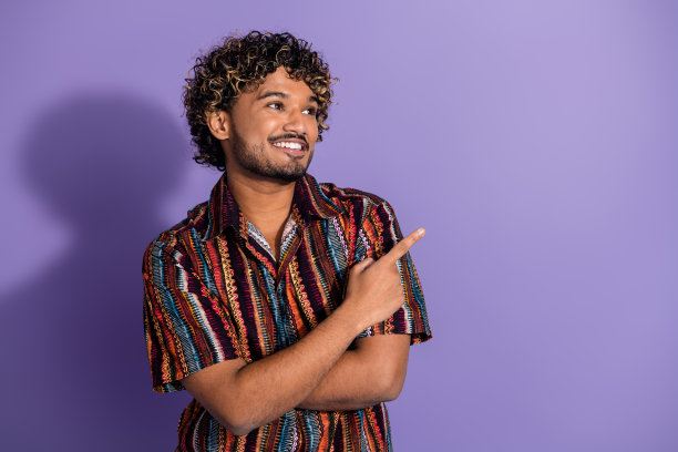 照片的好男人波浪发型穿着印花衬衫手臂折叠直接看标志空白空间孤立的紫色背景图片下载