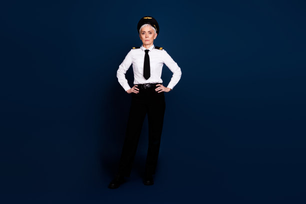 可爱的退休女士的全长照片，专业商业飞行员自信地穿着飞行员制服，孤立在深蓝色的背景图片下载