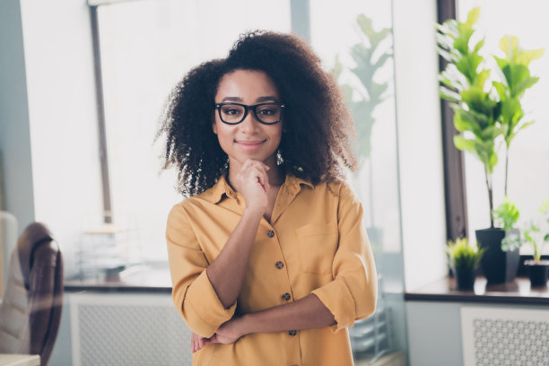 照片自信可爱的女孩穿着时髦的衣服摸下巴商务中心现代办公室室内工作场所车间图片下载
