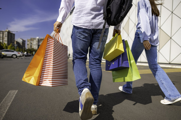 认不出来的一对，走在购物中心附近，两人都提着购物袋图片下载