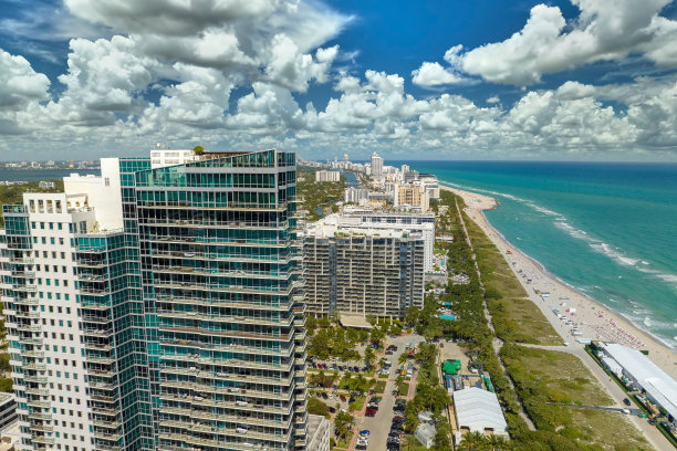 南海滩沙滩上，游客们在佛罗里达炎热的阳光下放松。美国南部的旅游基础设施。迈阿密海滨城市拥有高档豪华酒店和公寓图片下载