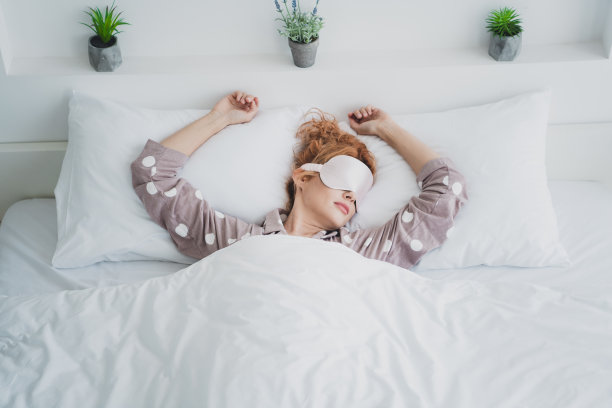 积极的好心情女人的俯视图照片，睡衣面具放松床在室内的房子公寓房间图片下载