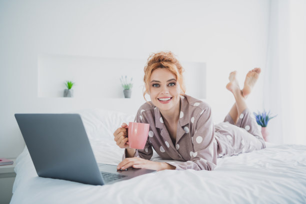 照片积极的好心情女人睡衣放松的床喝饮料聊天现代设备在室内房子公寓房间图片下载