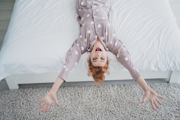 漂亮开朗的女士睡衣的俯视图照片，微笑着在家里的卧室里休息图片下载