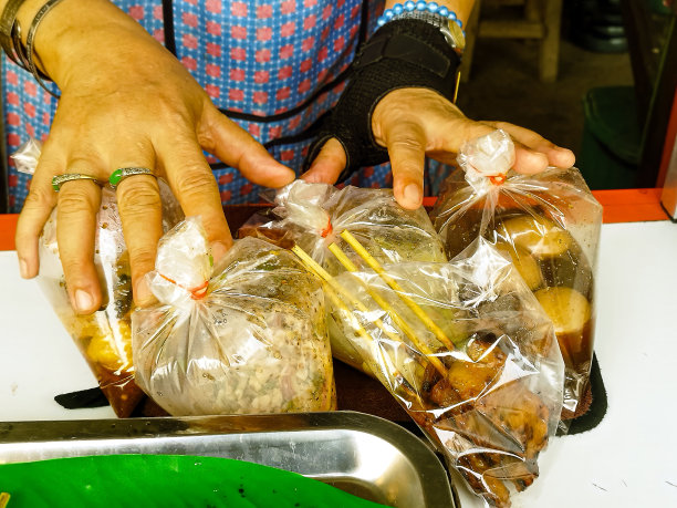 泰国清迈，顾客从一家街头小吃店买回家的各种热食物袋的照片。图片下载