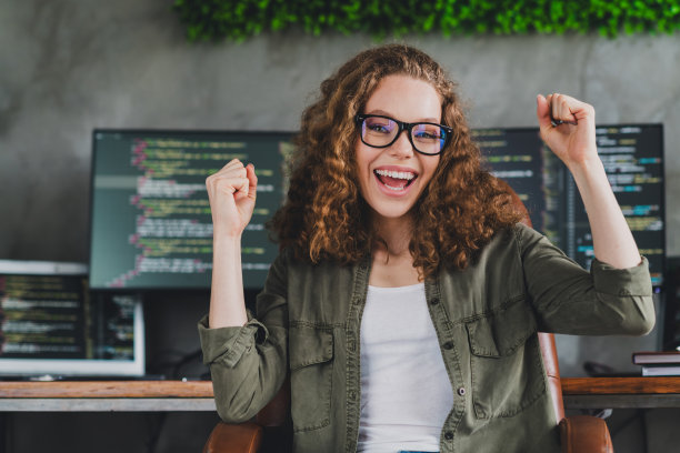 照片可爱的兴奋高兴的女人软件开发人员坐在扶手椅舒适的工作空间工作站室内图片下载