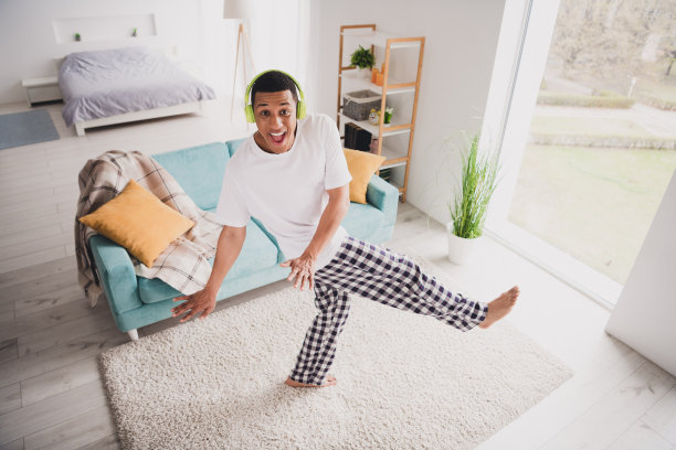 照片开朗的积极的家伙穿着睡衣耳机呆在家里玩在室内房子公寓房间图片下载