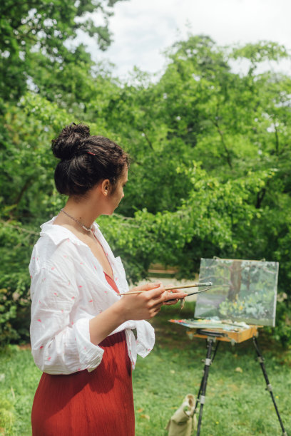 女艺术家在公园里画画。正念，艺术疗法，创意概念。在大自然中进行空气绘画的过程。一系列的照片展示了一幅画的一步一步的创作图片下载