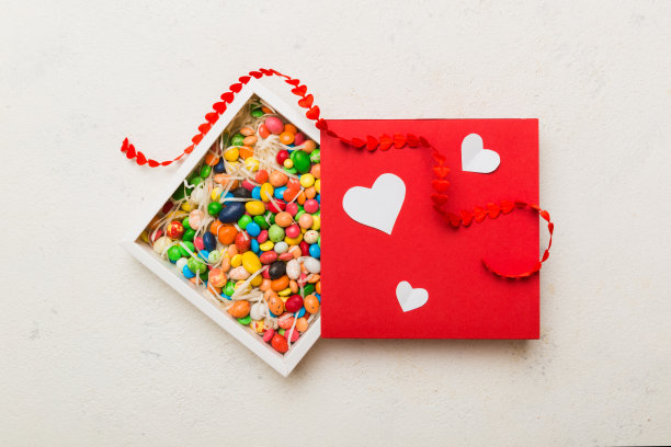 情人节作文:甜甜的糖果，带蝴蝶结和红心毡礼盒，照片模板，背景。带复制空间的俯视图图片下载