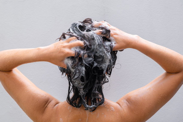 美丽女人的手她正在洗头，滋润头皮。洗发水和护发素图片下载