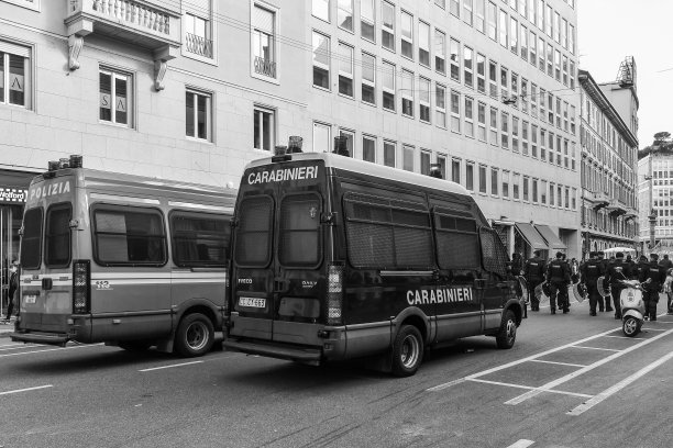 黑白照片。在意大利伦巴第米兰市中心的Corso Venezia路，警察、宪兵马车和防暴警察在传统的解放日游行中巡逻图片下载