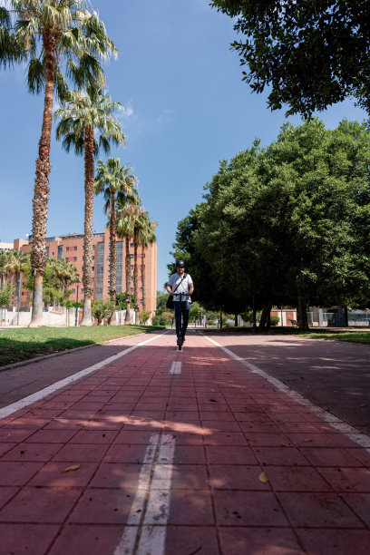 城市通勤:自行车道上骑电动滑板车的人图片下载