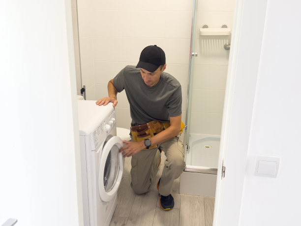 水管工在白色背景上修理洗衣机图片下载