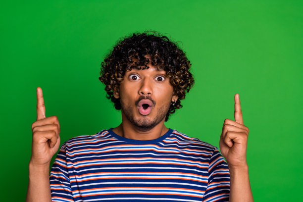 令人印象深刻的好男人的照片，穿着时髦的条纹衣服，在绿色背景上提供孤立的空白空间图片下载