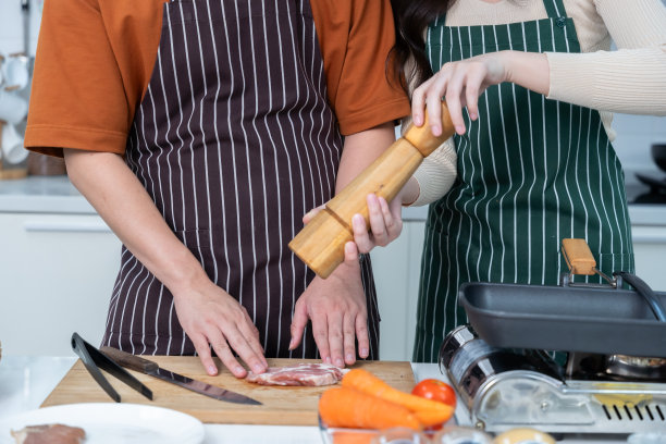 在准备好的肉类中加入胡椒粉，准备食物，享受烹饪与蔬菜，肉类，面包一起烹饪，而站在厨房公寓生活或家中图片下载