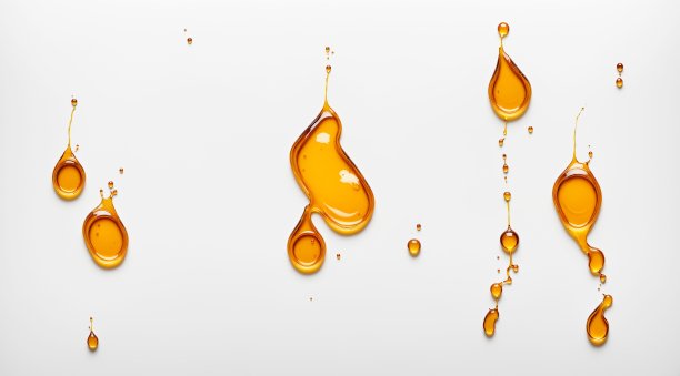 一张特写照片，金色的蜂蜜滴在白色的表面上。这种液体创造出有趣的图案和纹理。三维渲染图片下载