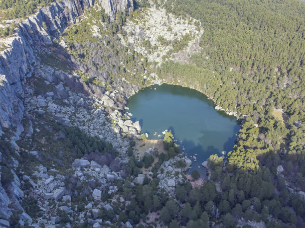 Soria省Laguna Negra de Urbion的航拍照片，这是一个冰川形成的泻湖，湖水碧绿，四周环绕着松树、山毛榉和一个岩石马戏团图片下载