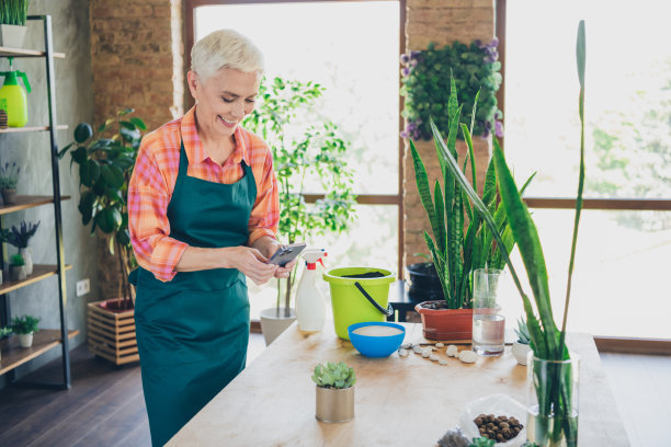 照片积极的好心情高级妇女穿着围裙护理花钉照片现代装置在室内的房子工作场所图片下载